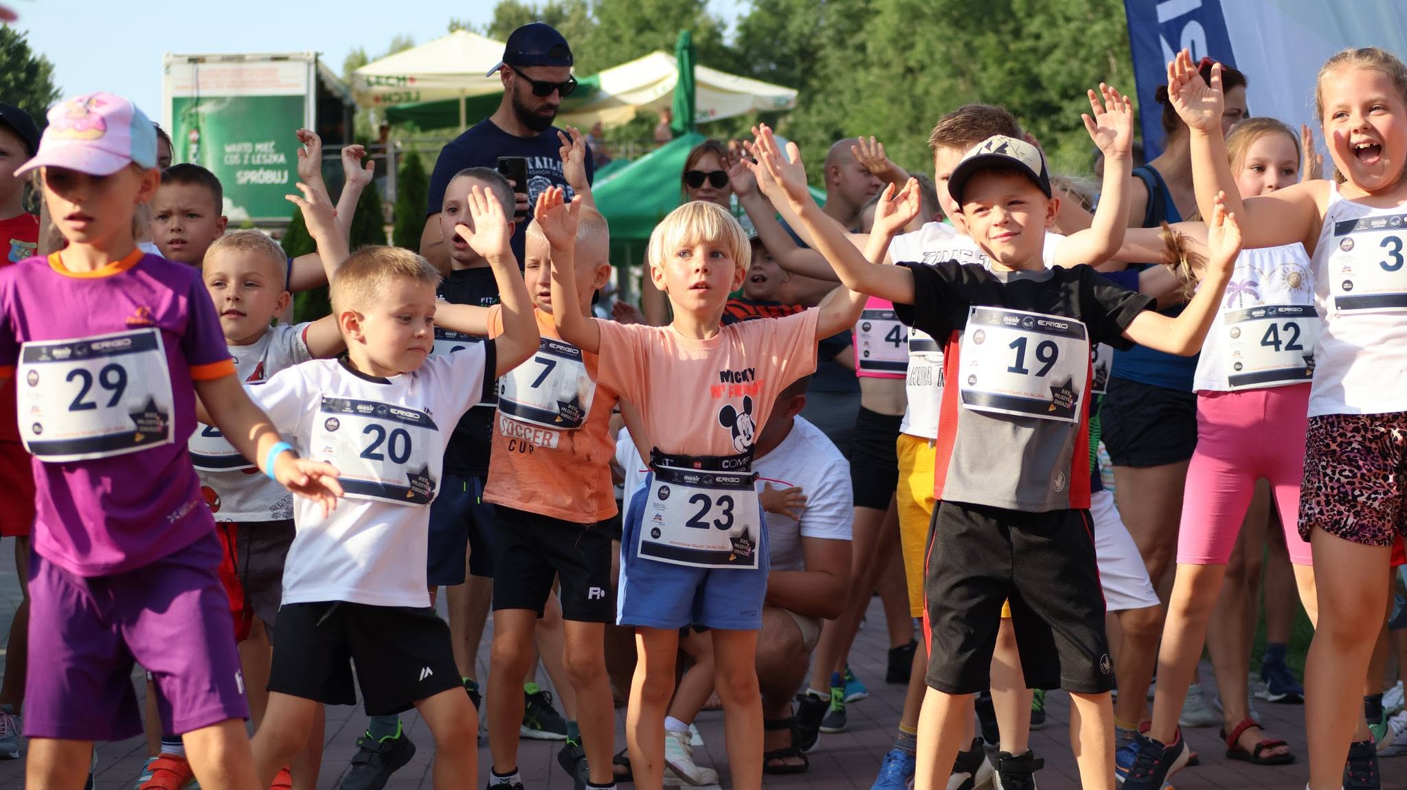 Dzieci, ręce podniesienie do g&oacute;ry, stoją w&nbsp;rzędzie, ćwiczą