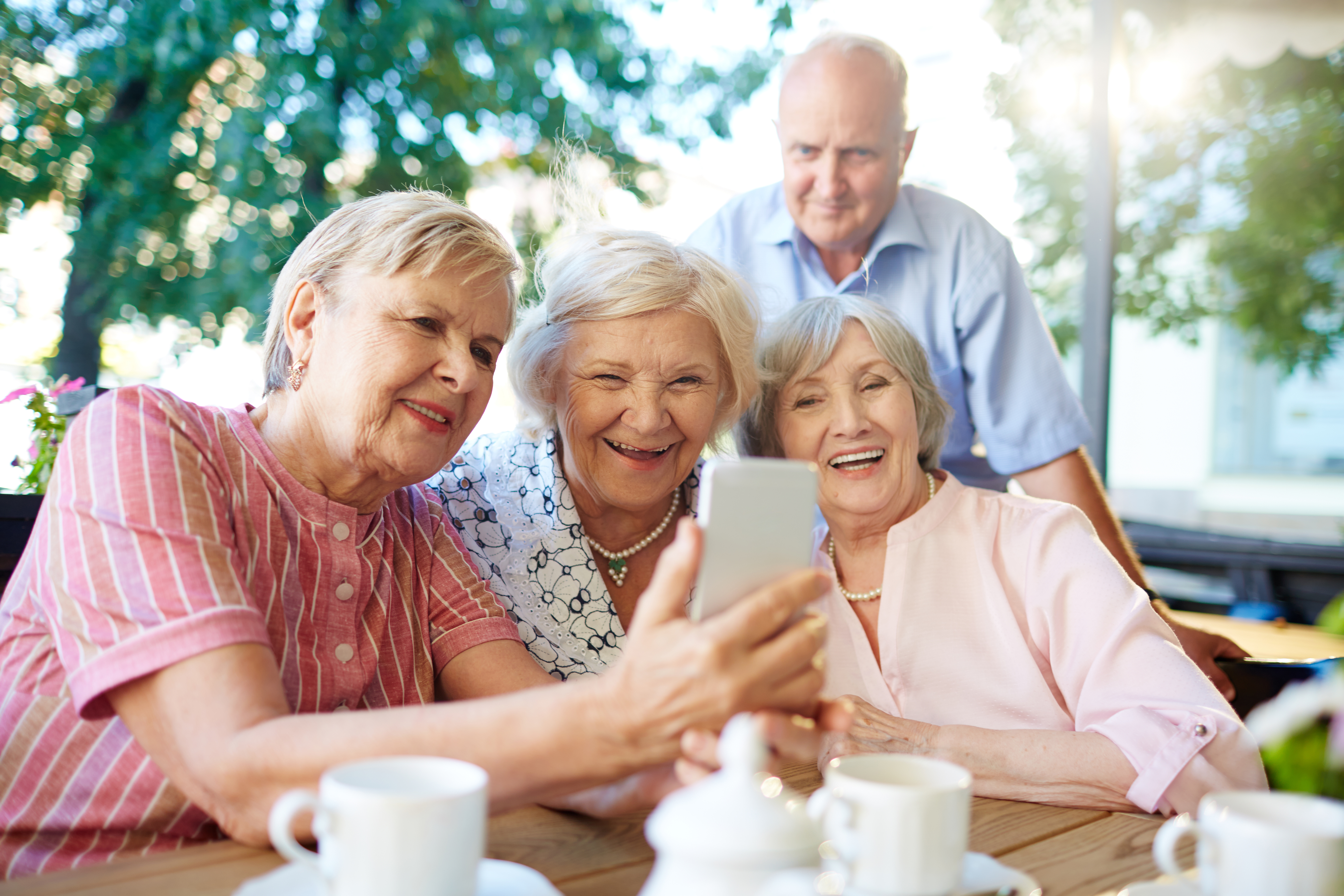 Seniorzy oglądają coś na&nbsp;telefonie 