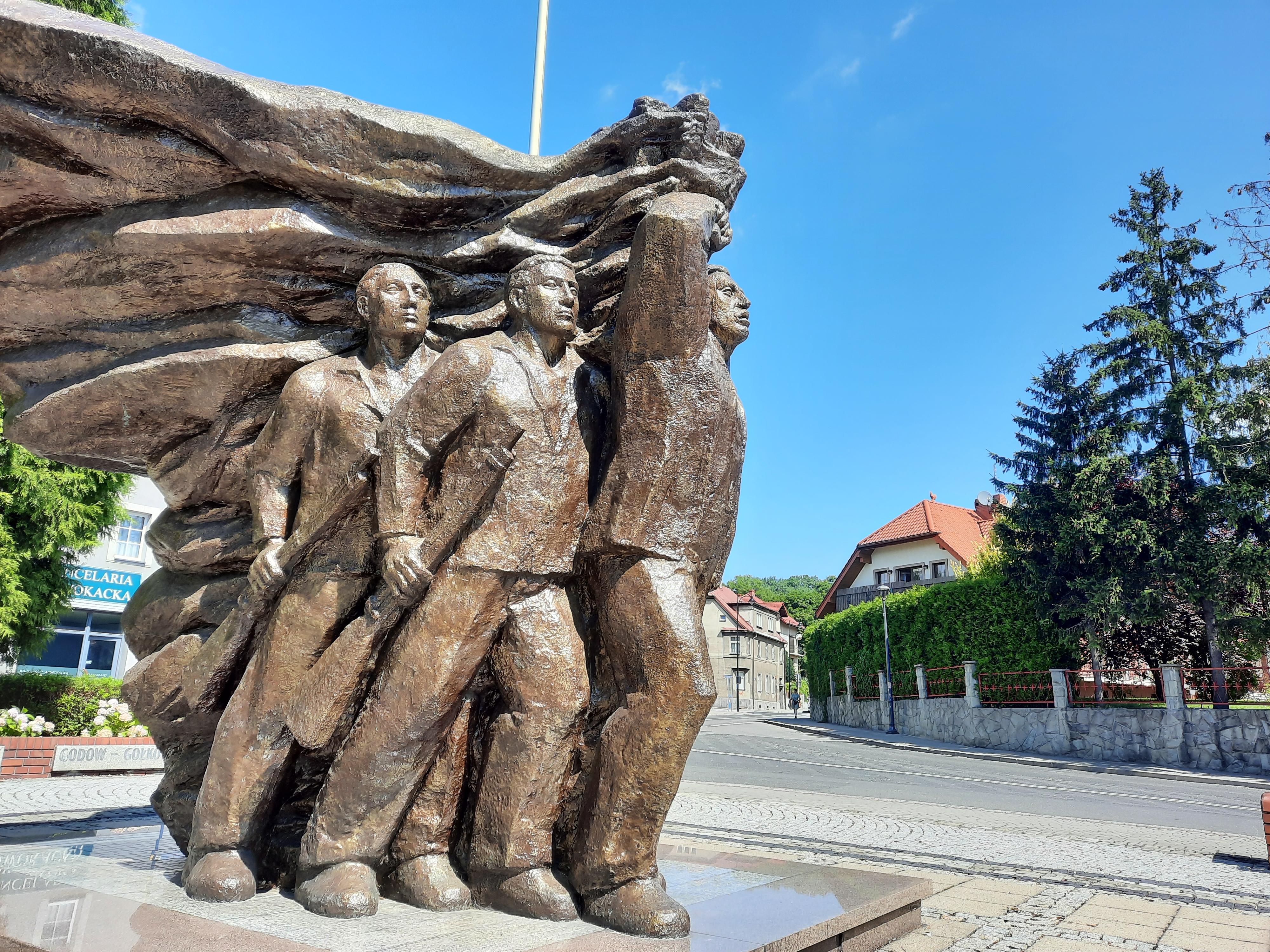Widok na pomnik Powstańców Śląskich w Wodzisławiu Śląskim, upamiętniający trzy wystąpienia zbrojne ludności śląskiej przeciwko władzom niemieckim, pomnik ma formę postaci powstańców śląskich maszerujących w zrywie powstańczym 