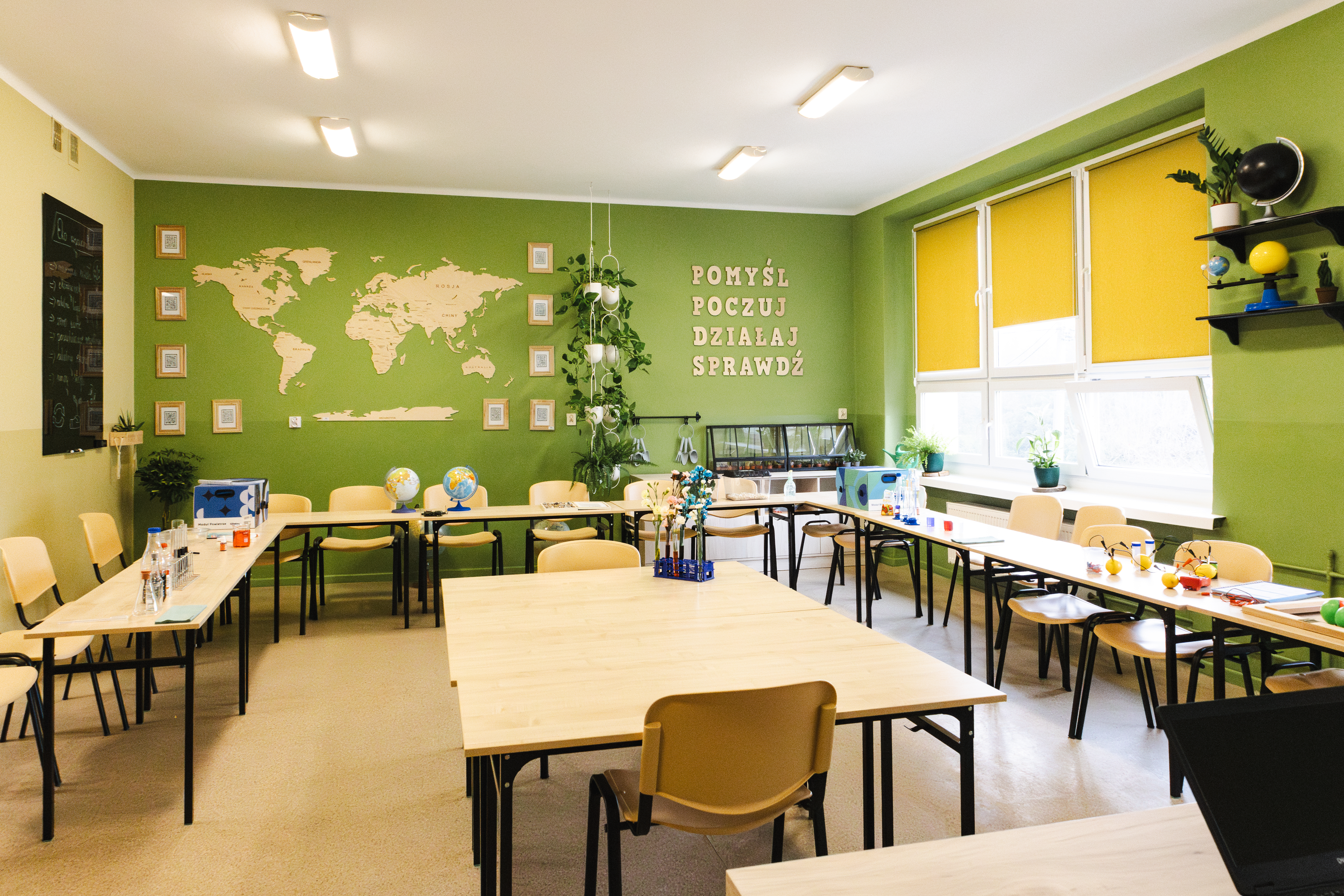 Klasa szkolna - zielona pracownia, z ielonymi ścianami, na ławkach porozkładane przyrządy do przeprowadzania doświadczeń