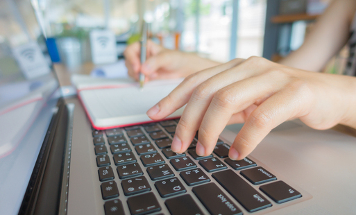 Zbliżenie na dłoń kobiety biznesu piszącą na klawiaturze laptopa